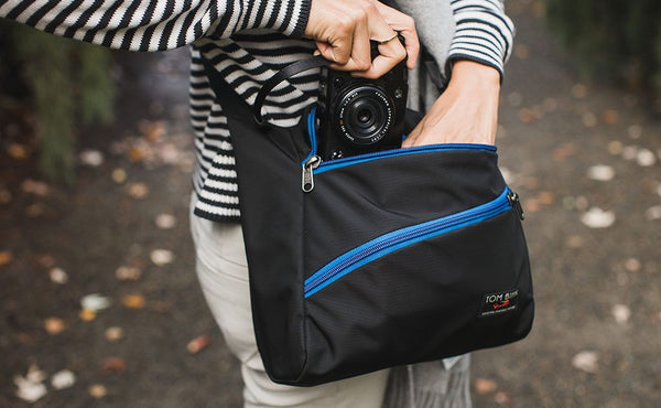 A person pulling a camera from the main pocket of the Icon.